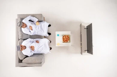 Omani Men Wearing Traditional Dress Watching TV Top View
