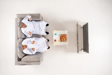 Omani Men Watching TV and Cheering Overhead View