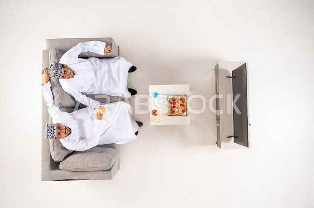 رجال عمانيون يشاهدون التلفاز منظور علوي