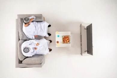 Two Omani Men Watching TV on Sofa Overhead View
