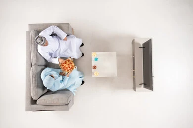 Omani Couple Eating Pizza on Sofa Top View