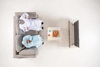 Omani Man and Girl Watching TV Overhead View