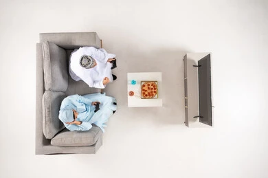 Omani Men in Traditional Dress Gaming on Sofa Top Down View