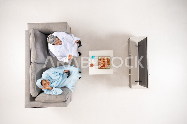 زوجان عمانيان يلعبان ألعاب الفيديو منظور علوي