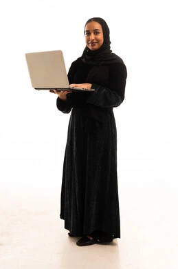 امرأة سعودية تحمل كمبيوتر محمول بالعباءة السوداء