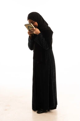 Saudi Woman in Black Abaya Kissing the Holy Quran