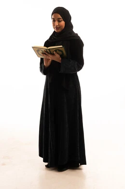 Arab Woman in Abaya Reading Quran on White Background Arab Woman in Abaya Reading Quran on White Background