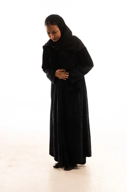 Saudi Woman in Black Abaya Holding Her Stomach in Pain