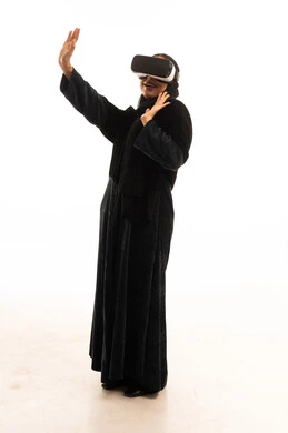 Saudi Woman Using Virtual Reality Headset in Black Abaya