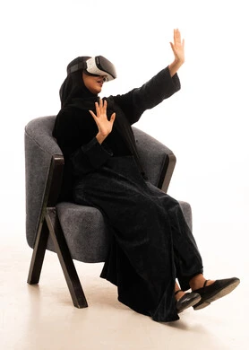 Saudi Woman Using VR Headset in Black Abaya