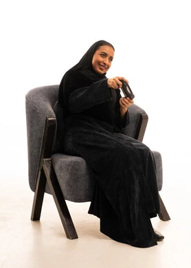 Saudi Woman in Abaya Gaming in Armchair