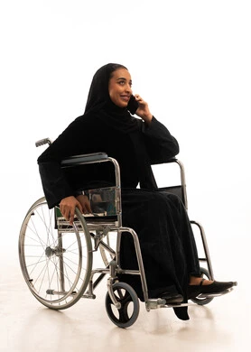 امرأة سعودية على كرسي متحرك تستخدم الهاتف الذكي