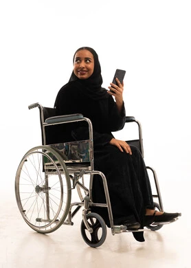 امرأة سعودية على كرسي متحرك تستخدم هاتف ذكي