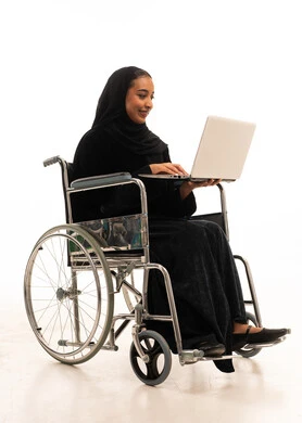 امرأة سعودية على كرسي متحرك تستخدم الحاسوب المحمول