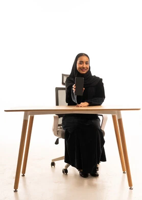 Saudi Woman in Abaya Holding Smartphone at Office Desk