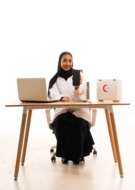 طبيبة سعودية تحمل هاتف ذكي في مكتب طبي بخلفية بيضاء