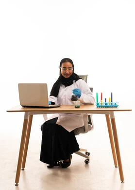 عالمة سعودية مع معدات مختبر وجهاز كمبيوتر