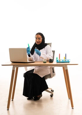 عالمة سعودية مع كمبيوتر محمول وأنابيب اختبار