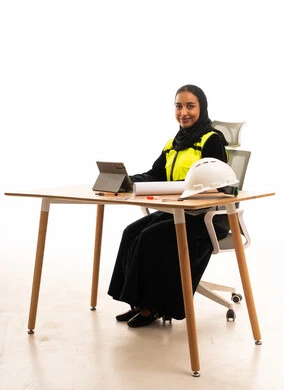 Saudi Female Engineer at Office Desk with Safety Gear
