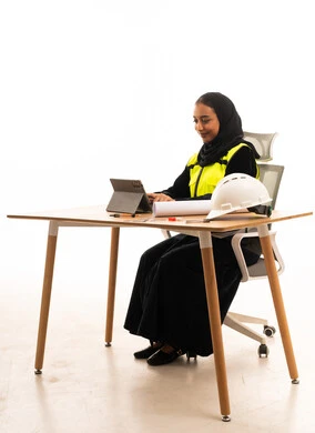 Saudi Female Engineer Working with Tablet and Blueprints
