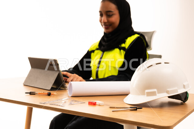 مهندسة سعودية تعمل على جهاز لوحي في مكتب حديث
