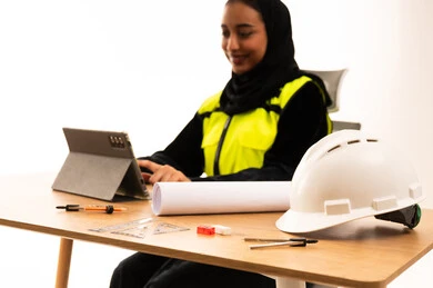مهندسة سعودية تعمل على جهاز لوحي في مكتب حديث