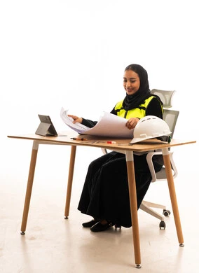 Saudi Female Engineer with Blueprints in Office