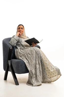 Saudi Woman in Traditional Jalabiya Reading Book