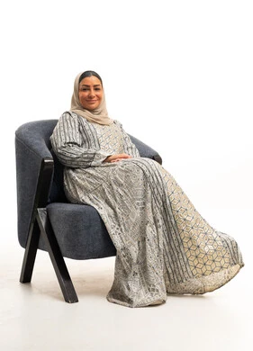 Saudi Woman in Traditional Jalabiya Sitting in Armchair