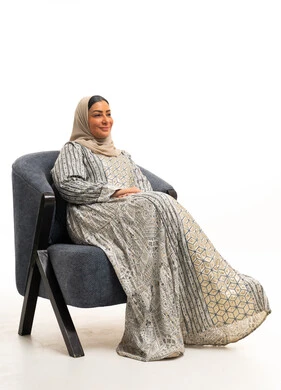 Saudi Woman in Traditional Jalabiya Sitting on Armchair