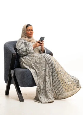Saudi Woman in Traditional Jalabiya Using Smartphone