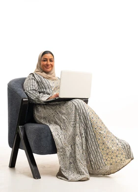 امرأة سعودية بالجلابية التقليدية تستخدم الحاسوب المحمول