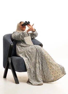 امرأة إماراتية باللباس التقليدي تنظر من خلال المنظار