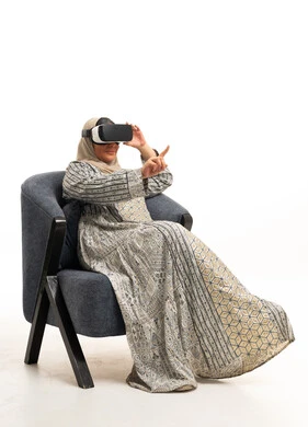Emirati Woman Using VR Headset in Armchair
