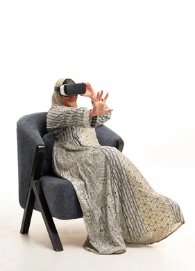 Elderly Arab Woman in Abaya Using VR Headset in Studio