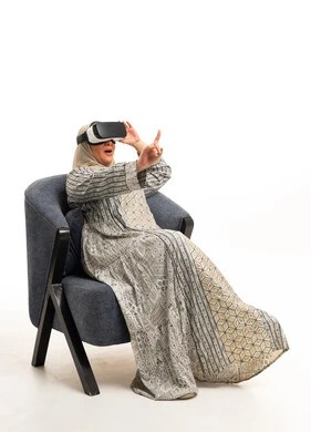 Elderly Arab Woman Using VR Headset in Armchair