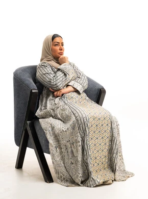 Arab Woman in Patterned Jalabiya Thinking in Armchair