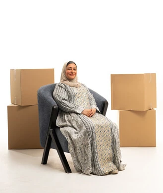 Saudi Woman in Jalabiya with Moving Boxes in Studio