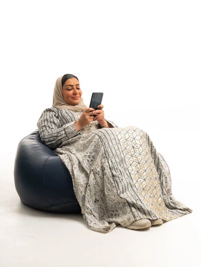 Emirati Woman in Traditional Jalabiya Using Smartphone
