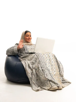 امرأة إماراتية تستخدم الكمبيوتر المحمول على مقعد محشو