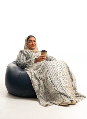 Saudi Woman in Abaya Sitting on Beanbag with Coffee
