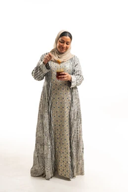 امرأة إماراتية تمسك مرطبان عسل في الاستوديو امرأة إماراتية تمسك مرطبان عسل في الاستوديو