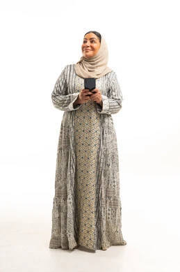 Saudi Woman in Traditional Jalabiya Holding Smartphone