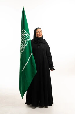 امرأة سعودية مع العلم الوطني في الاستوديو