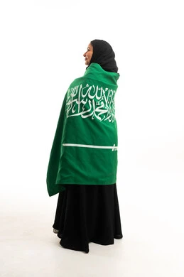Saudi Woman Wrapped in National Flag on White Background