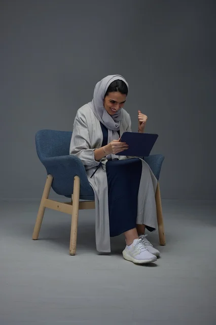 امرأة سعودية تستخدم جهاز لوحي وتحتفل بالنجاح