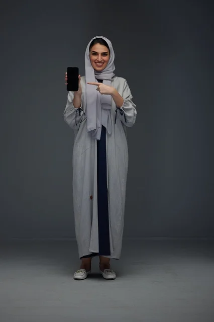 امرأة سعودية تشير إلى شاشة هاتف ذكي فارغة