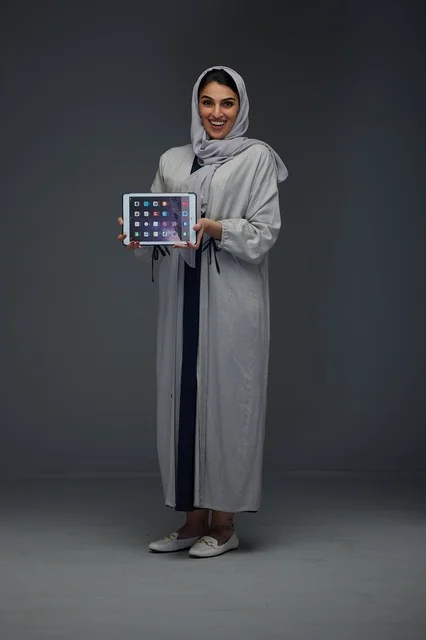 امرأة سعودية في الاستوديو تحمل جهاز لوحي رقمي