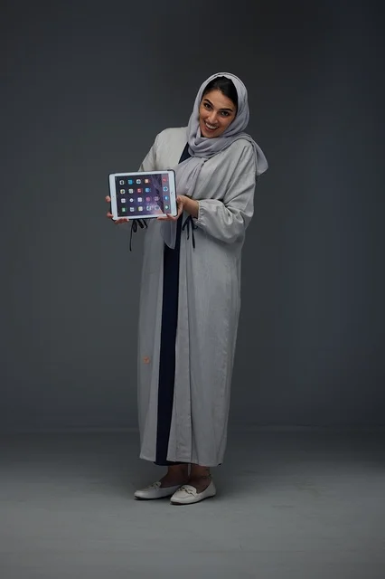 Saudi Woman Holding Tablet Computer in Studio Wearing Abaya