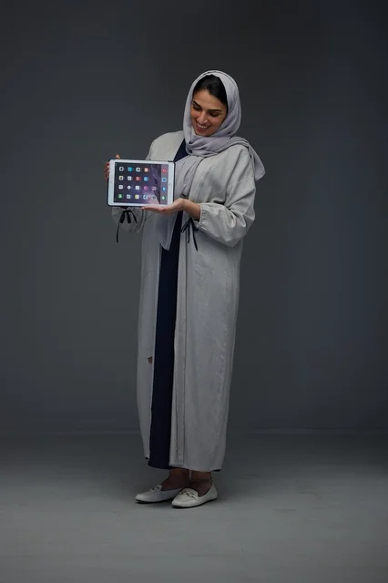 Saudi Woman Holding Tablet in Studio Wearing Abaya